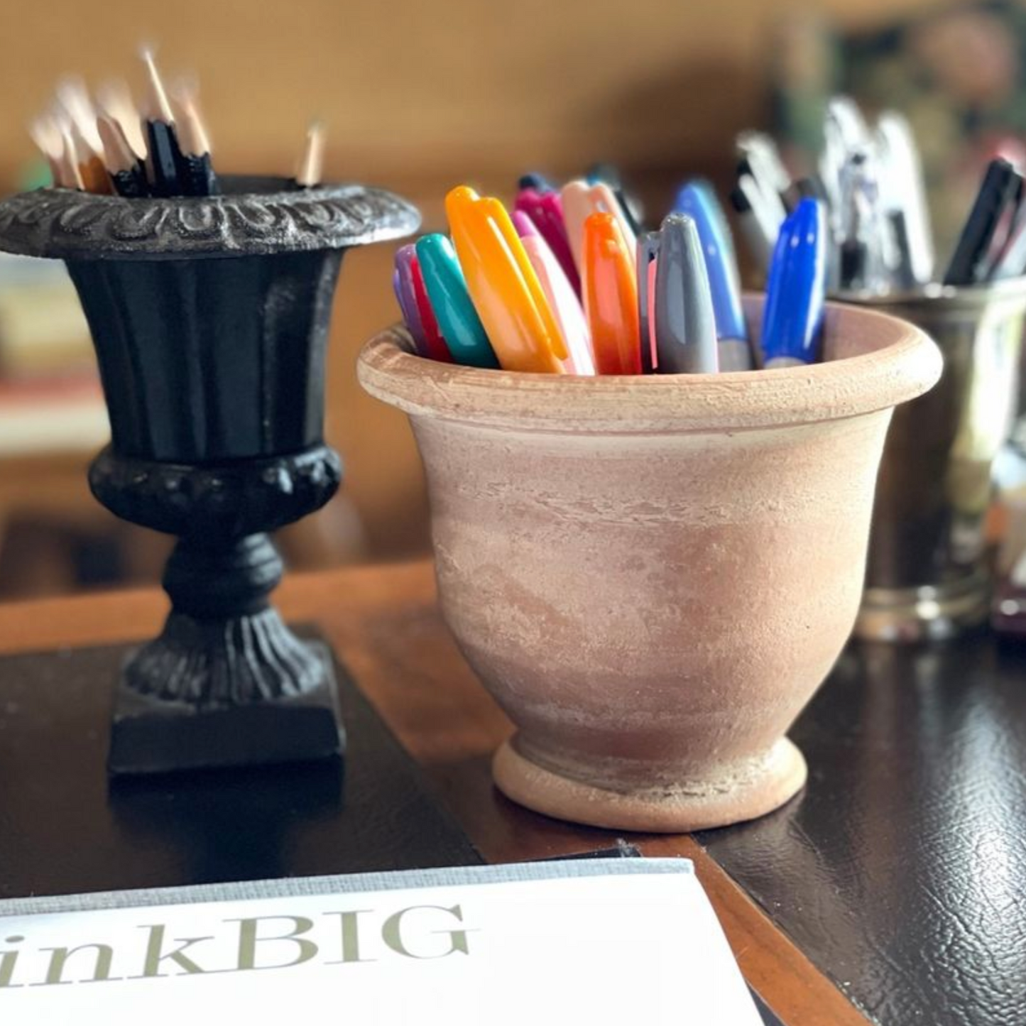 Potier - small on desk filled with colored sharpies.