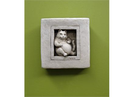 This Sculpture has a fat cat setting in a window with the word relax below it.