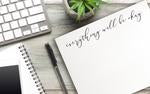 a picture of the notepad next to a notebook and a computer keyboard.