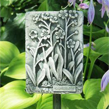 The Forget-me not plaque shown amongst green folilage.