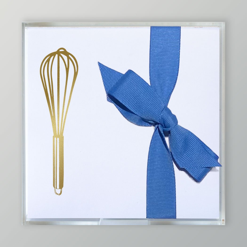 A photo of the Gold Embossed Kitchen Whisk on 5 x 5 stationery paper tied with a blue ribbon