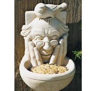 A picture of the Bird Watcher Bird Feeder hanging on a fence filled with bird seed.