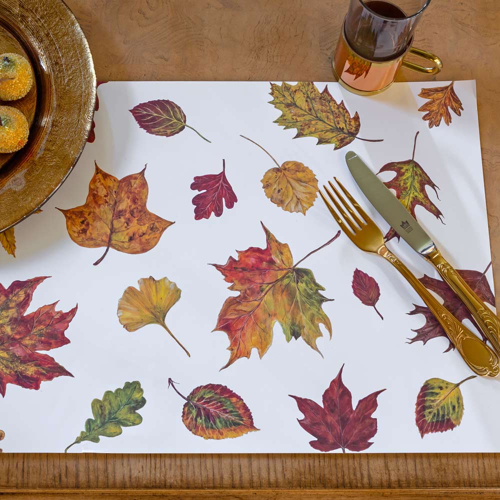 A photo of the fall placemat. Shown with gold silverware and copper pieces for the ultimate fall tablescape