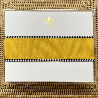 The Gold embossed note pad shown with a gold ribbon around it.  