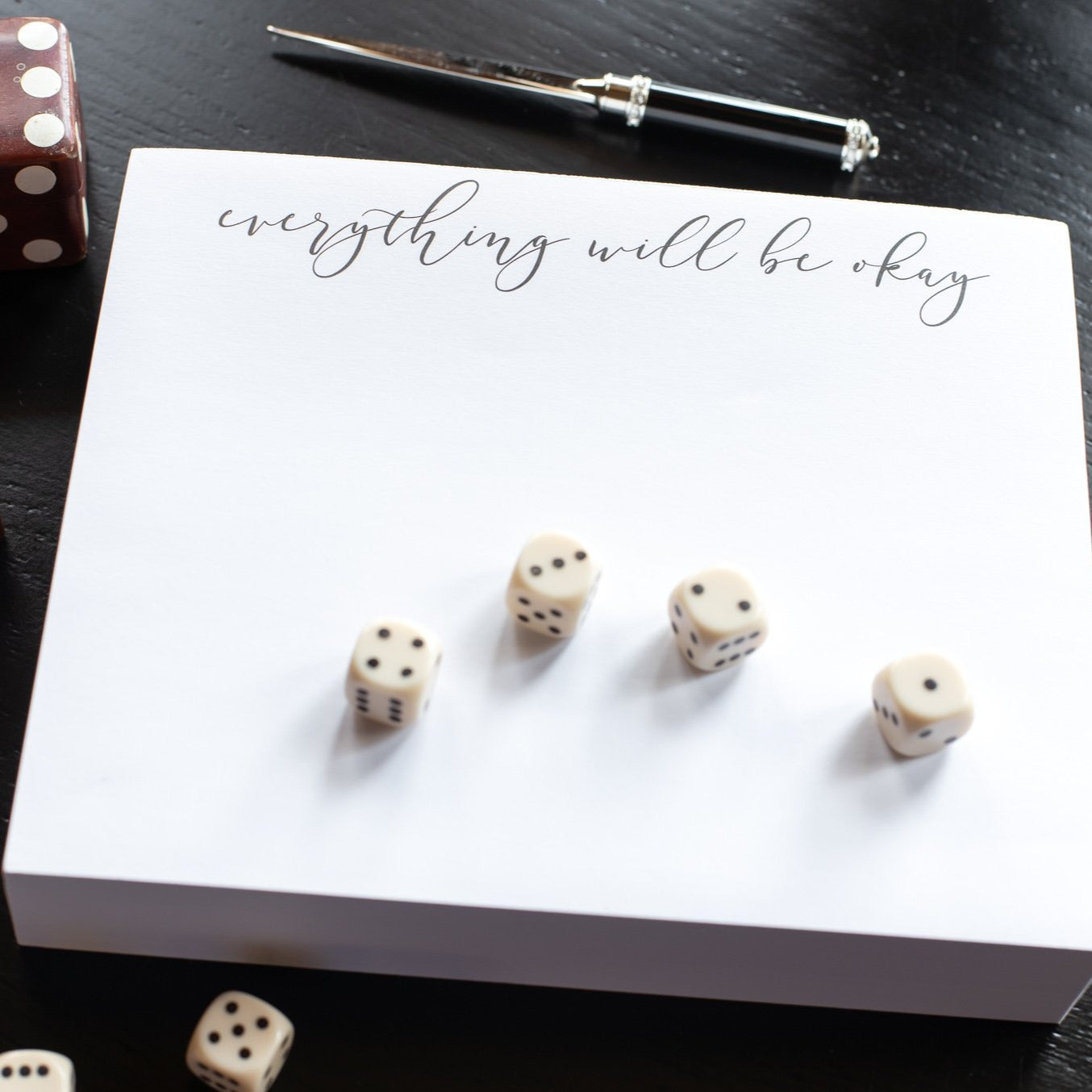 A picture of the notepad with the saying of "everything will be okay" It has grey/black writing on white paper.