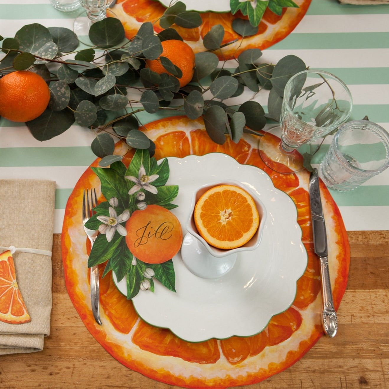 A photograph of a place setting using the orange slice paper placemat