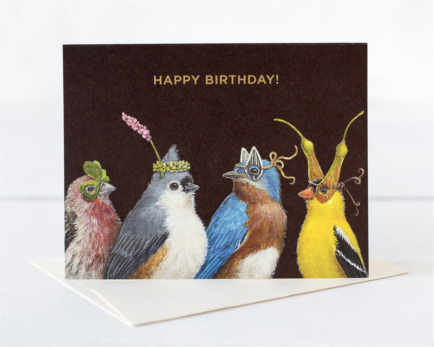 Four ladybirds dressed for a Birthday celebration wearing leaves, seeds and flowers as hats