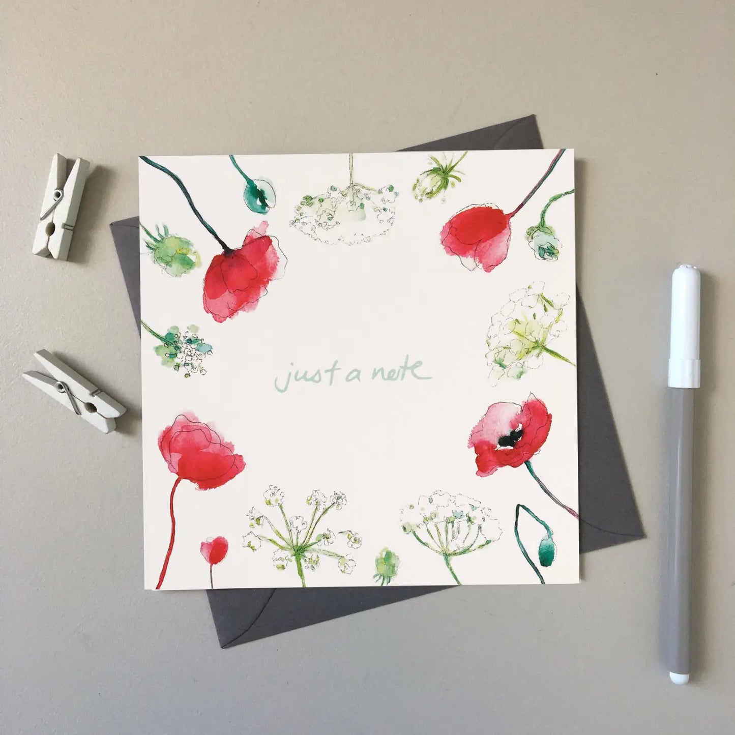 Just a note greeting card is surround by poppies and other sweet flowers.