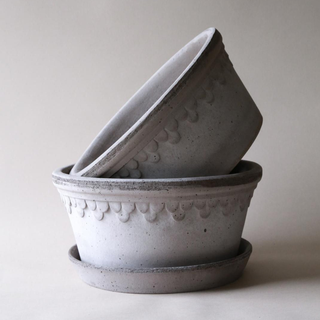 Two gray ceramic pots with decorative patterns on a light background