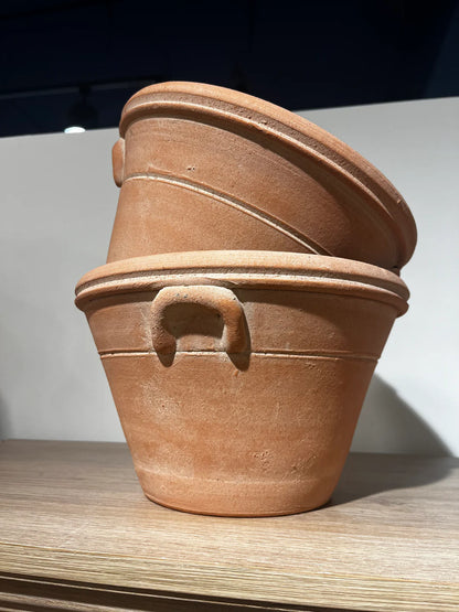 Two natural clay Provence pots stacked on a tilt with each other.