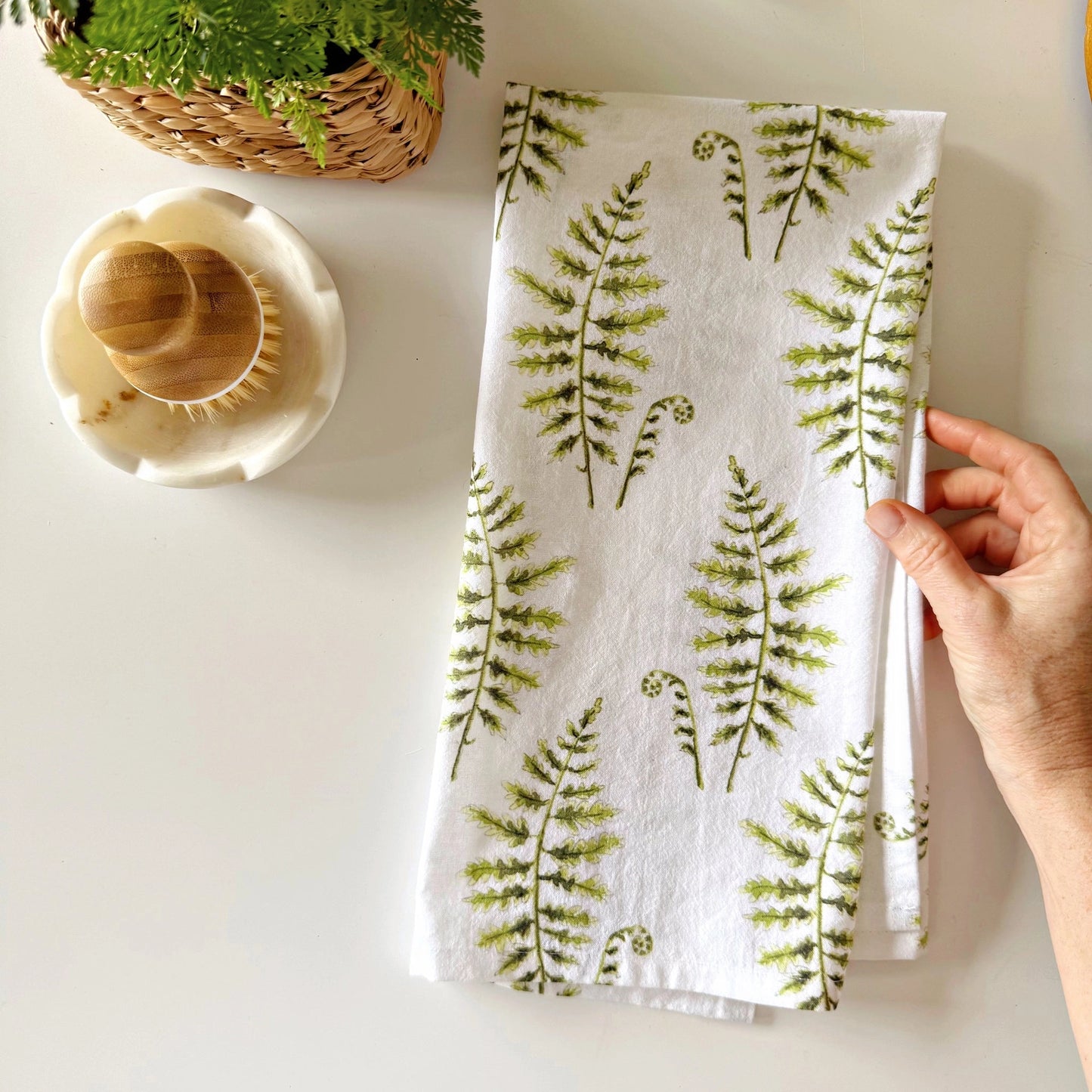 Alt Text: Emily Lex Fern Tea Towel folded with delicate watercolor green fern leaves.