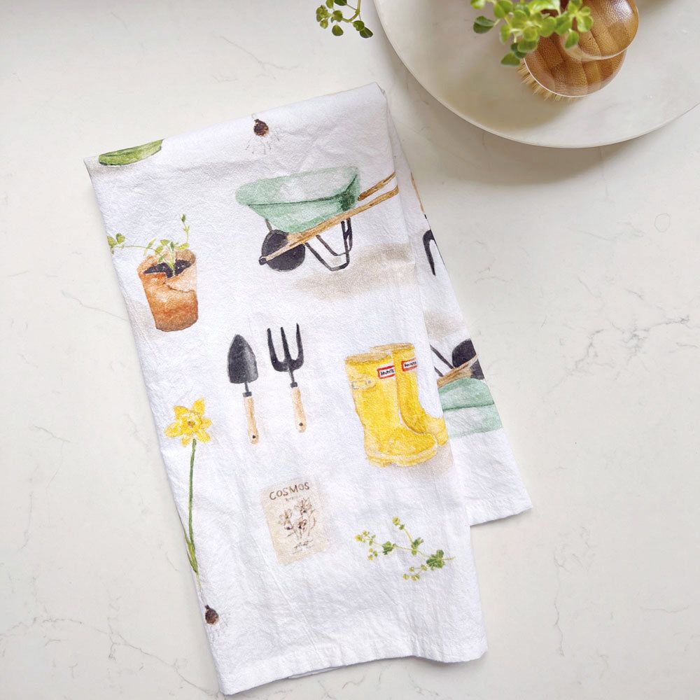Emily Lex Gardening Tea Towel folded with watercolor garden tools and flowers