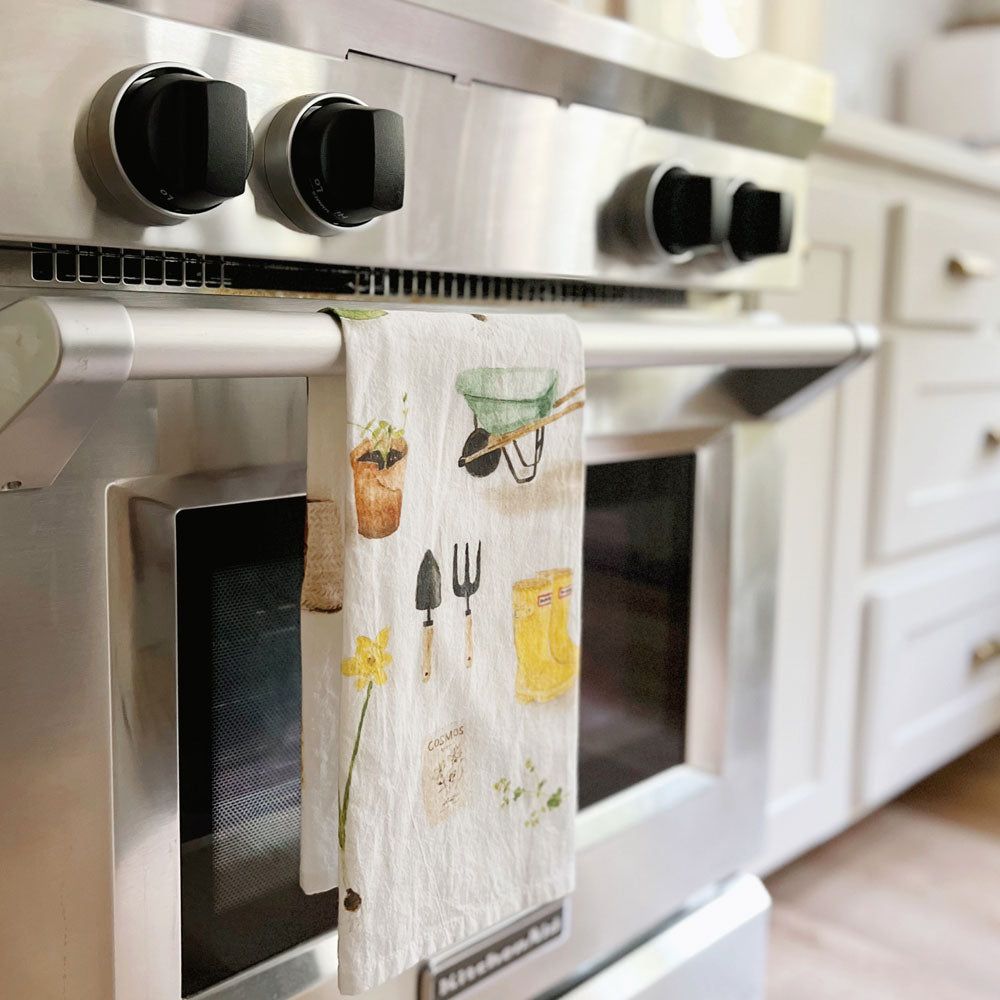 Emily Lex Gardening Tea Towel hanging on the oven door.