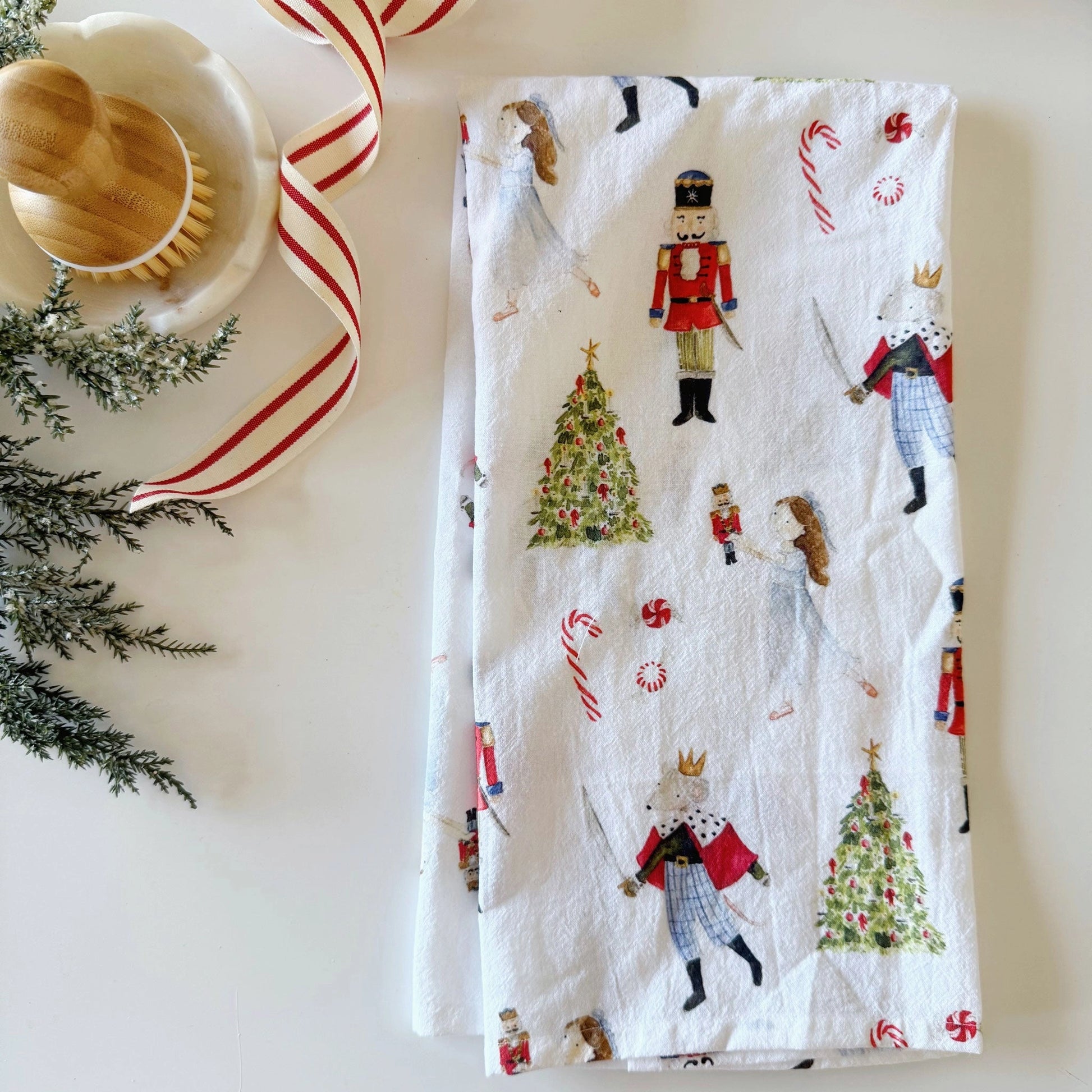 Emily Lex Nutcracker Tea Towel featuring watercolor nutcracker soldiers on a white background.