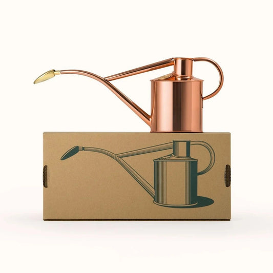 Haws Rowley Ripple Watering Can - 2 Pint Copper shown setting on its box.