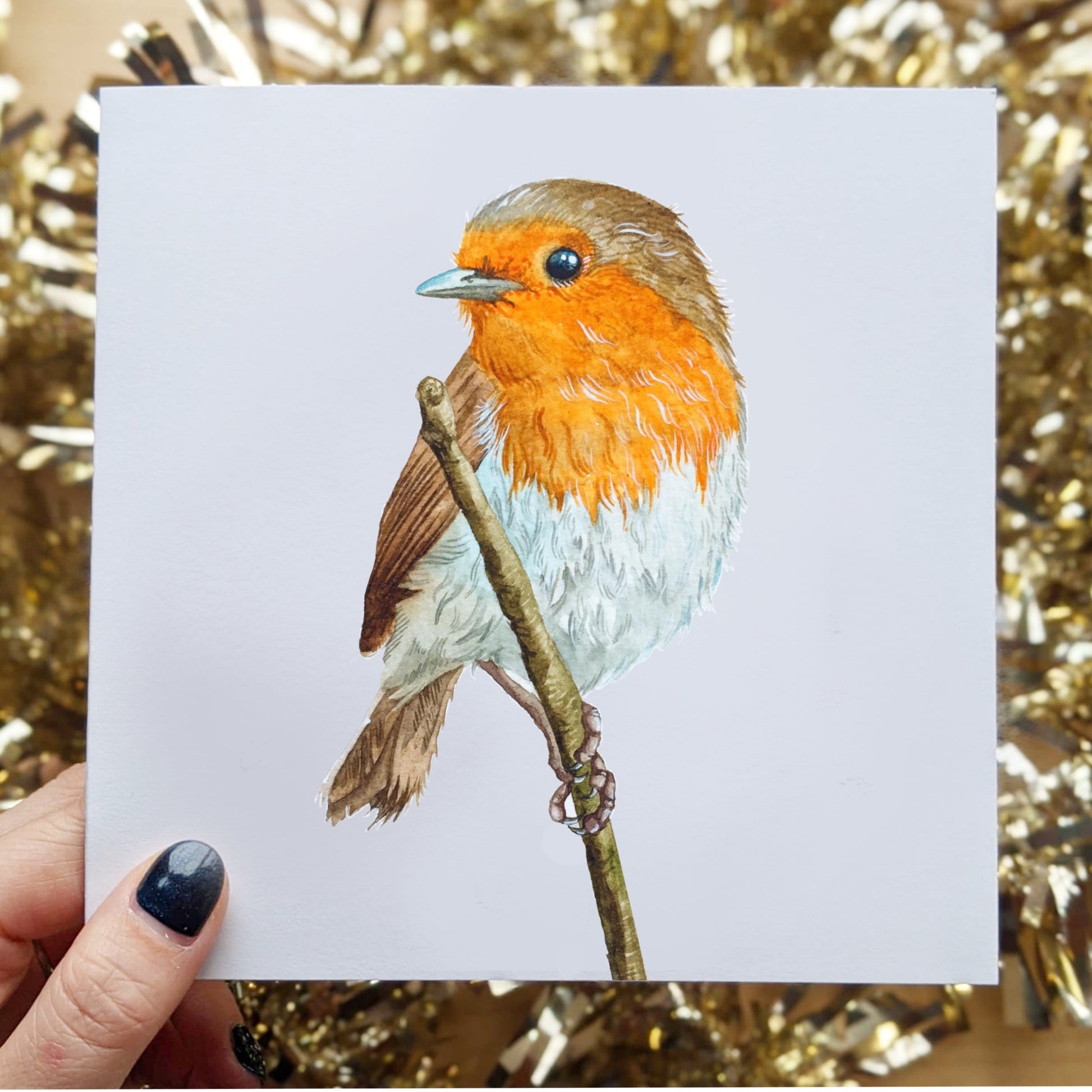 A picture of a watercolor greeting card of a baby robin. The colors are bright and detailed beautifully.