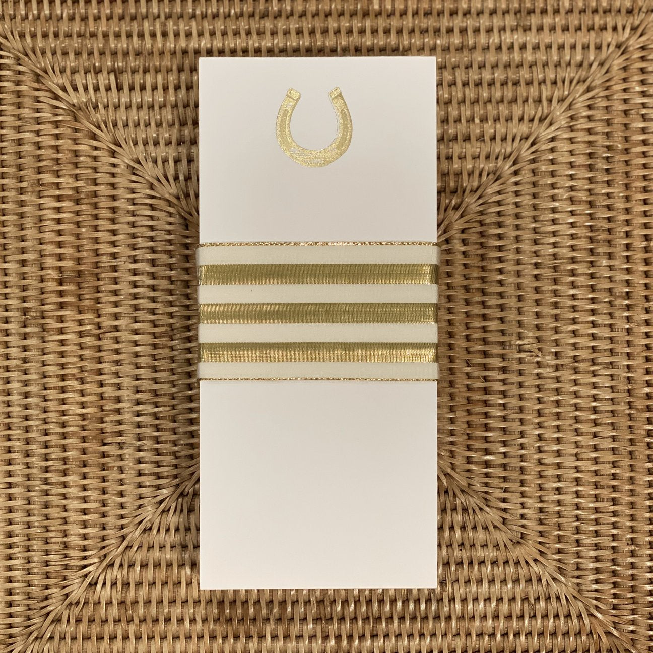 A photo of the Gold Horseshoe Buck Note Pad with a gold ribbon around it.