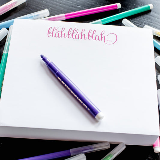 A photo of the Blah blah blah note pad shown with colorful felt pens scattered about.