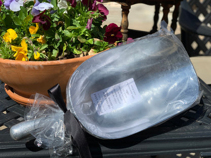 a picture of the Garden Aluminum Scoop packaged for gift-giving. enclosed in a cellophane bag tied with a satin black ribbon.