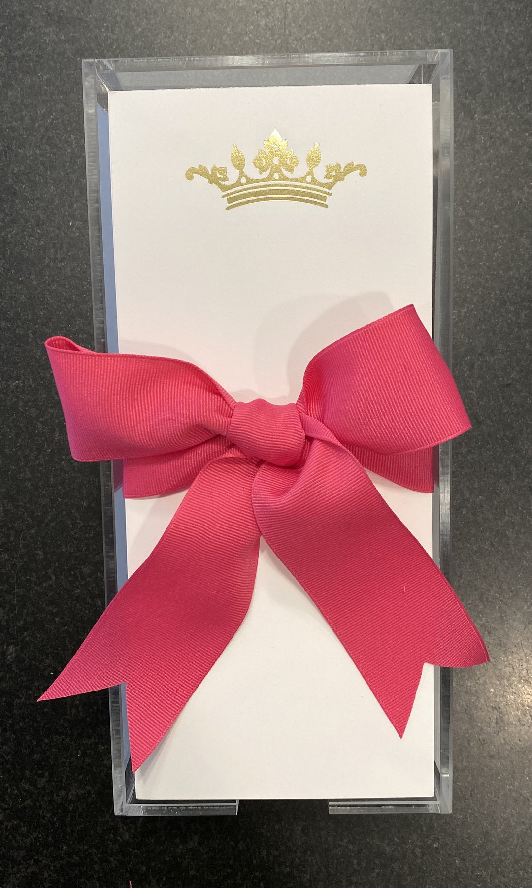 A photo of the Gold Embossed Crown note pad with a pink bow.