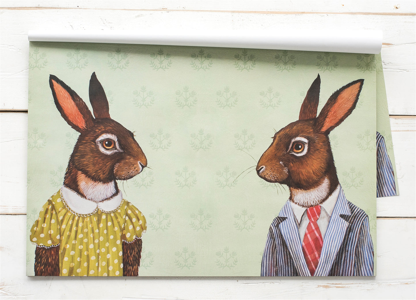 A placemat with a female and a male rabbit facing each other dressed for a meal. This placemat has be a best seller. 
