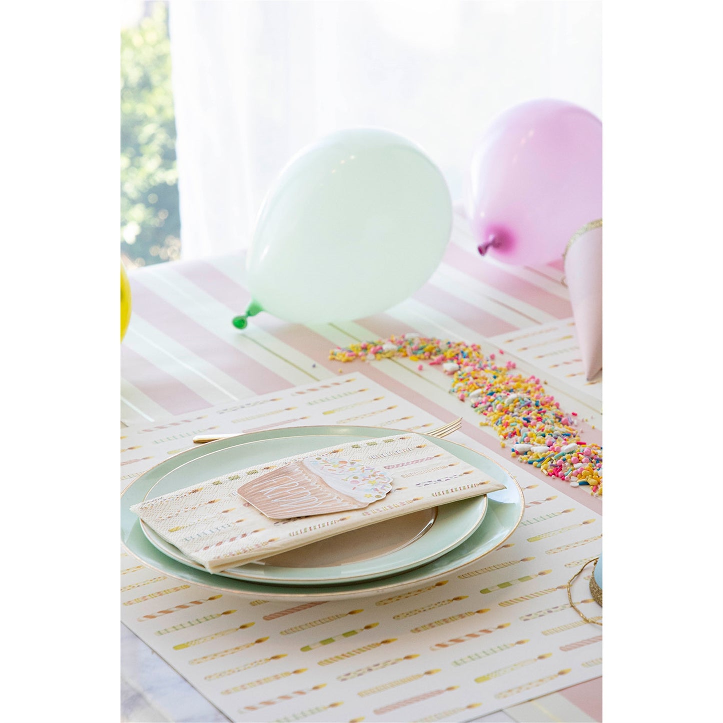 Showing a table setting using the birthday candles paper placemats with balloons and place card and candy.