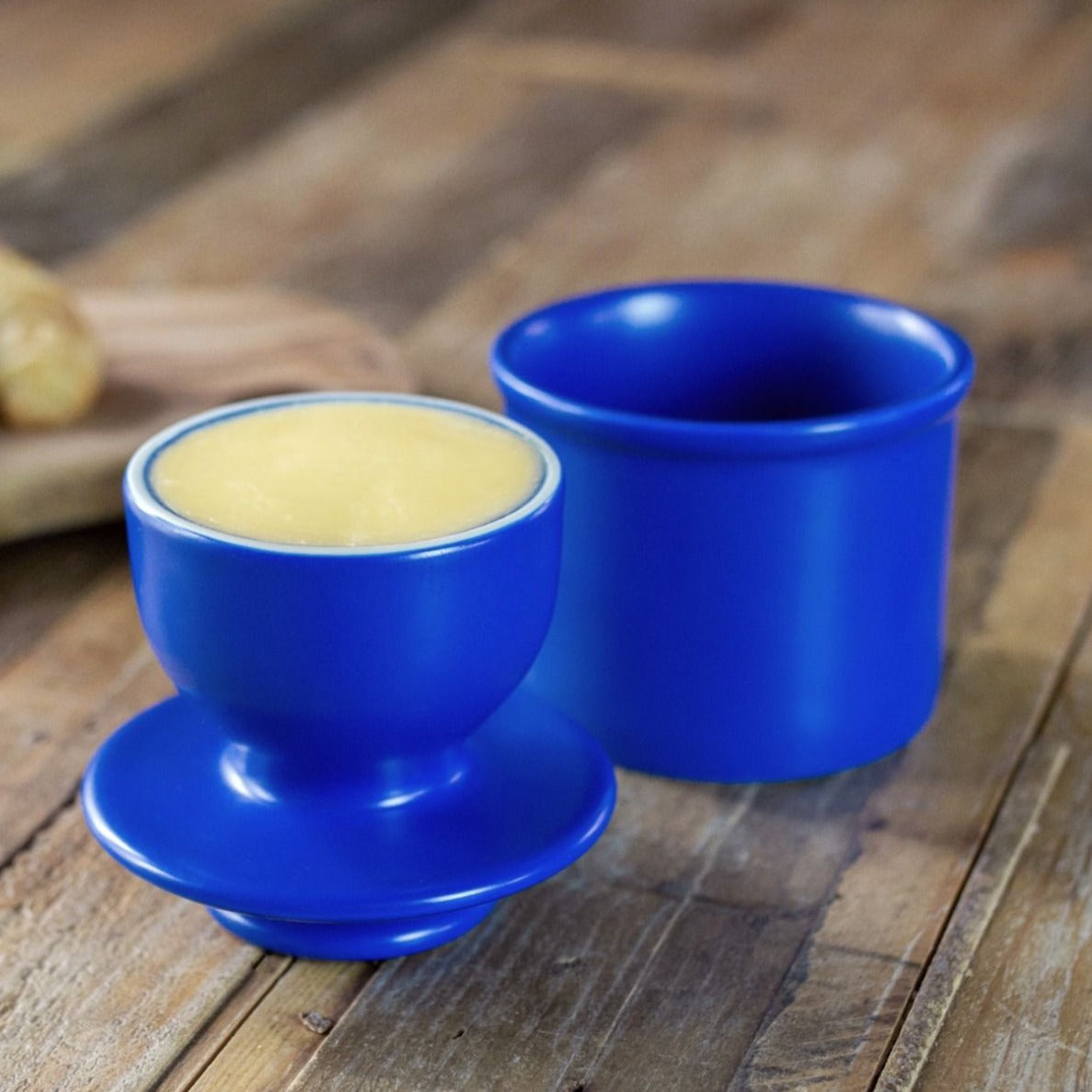 The Matte Peacock Blue Butter Bell shown with the lid off so you can see the shape of the beel with butter in it.