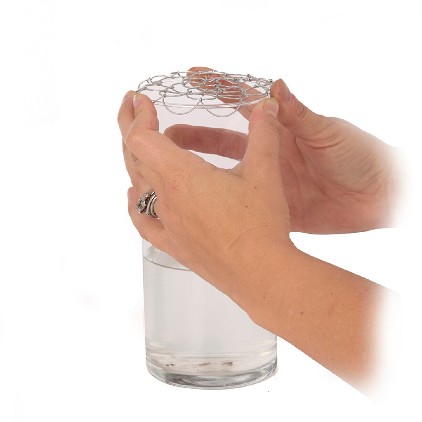 showing how to place the easy arrange doily over the top of a vase so that you can place the flower stems in each of the holes.