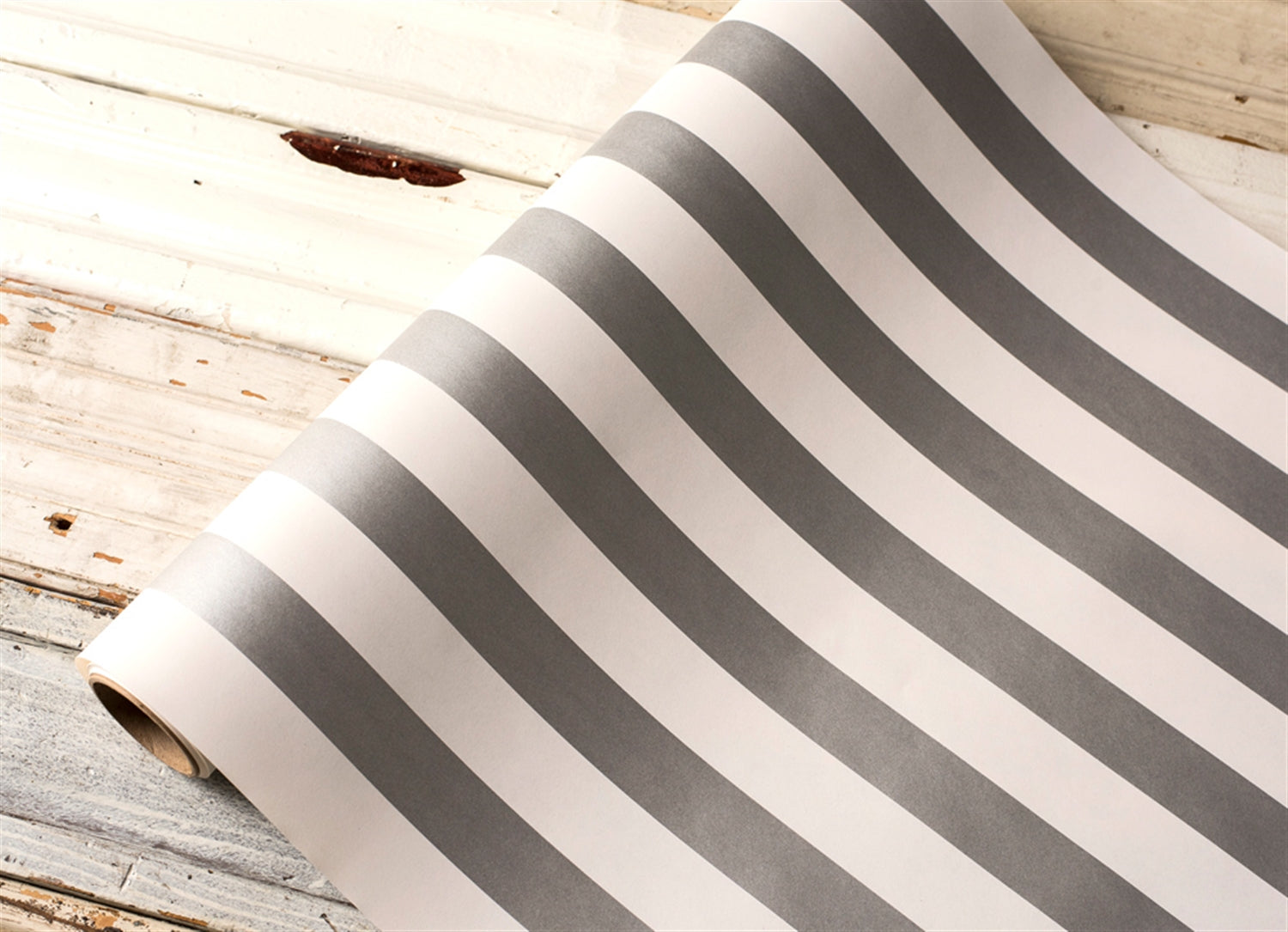 A close up of the silver and white striped Paper table runner.