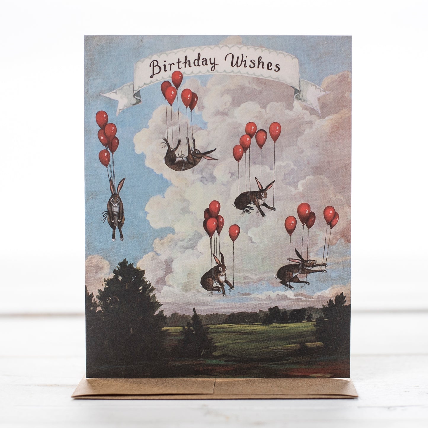 Birthday card message with rabbits floating in the air tied to red balloons. So much fun.